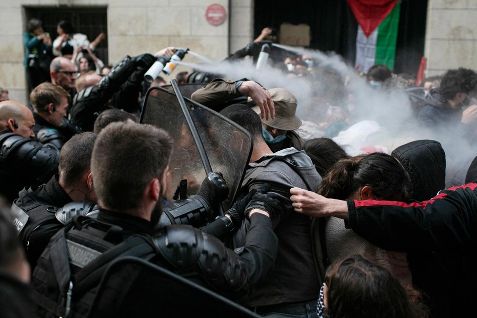 Polizisten gehen mit Pfefferspray gegen Teilnehmer:innen eines Protestcamps an der Sorbonne-Universität in Paris vor